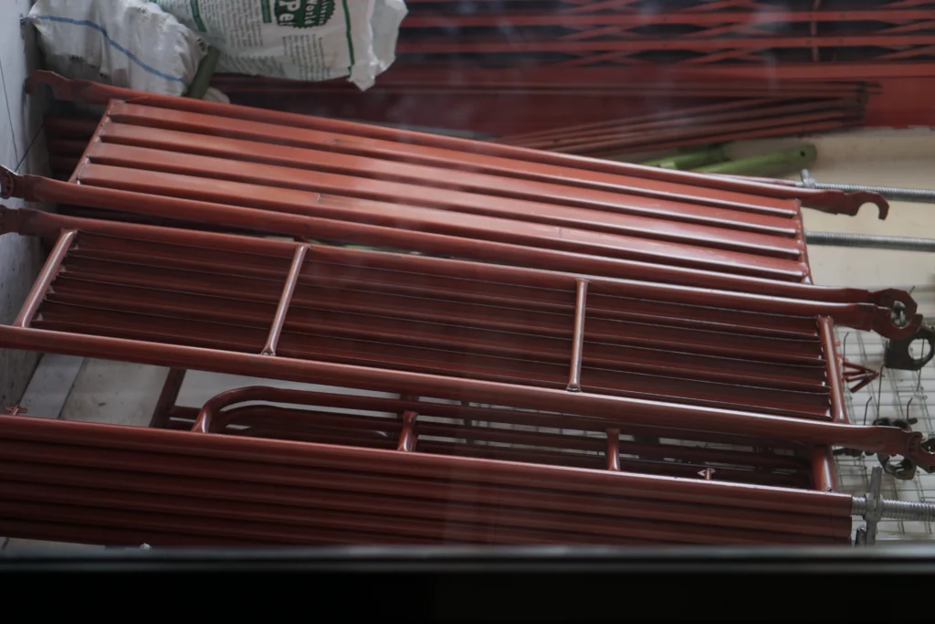 Tumpukan scaffolding frame merah di gudang Gerbang Emas